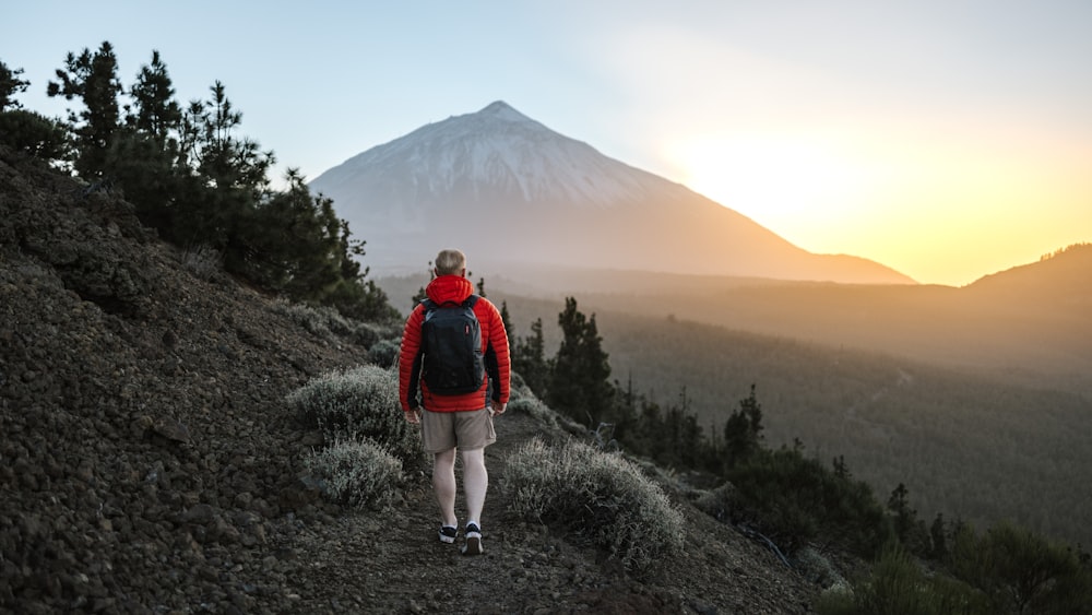 a man with a backpack walking up a hill