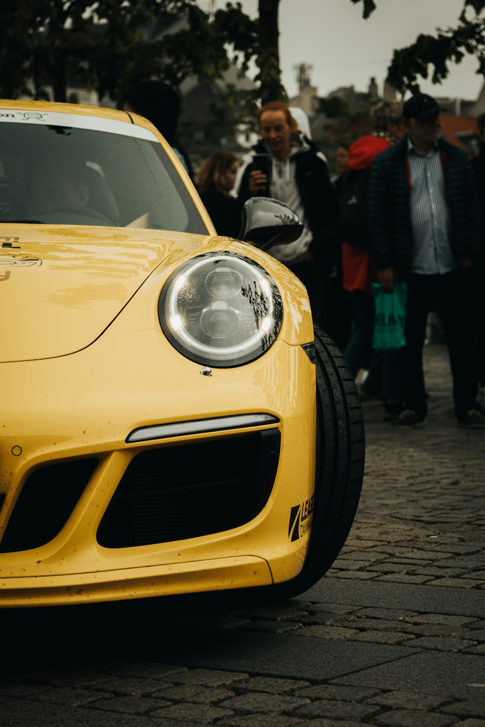 a yellow sports car parked on the side of the road