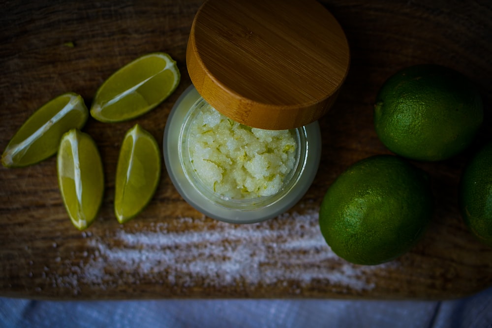 limes, sugar, and lime slices on a cutting board