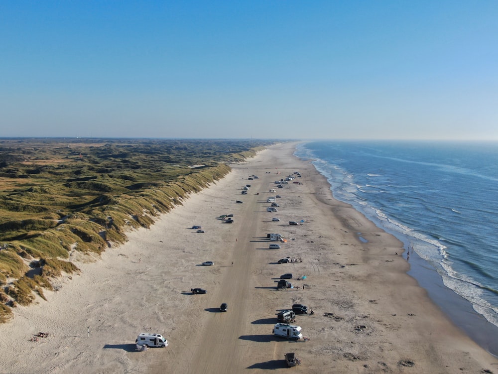 an aerial view of a beach with cars parked on it