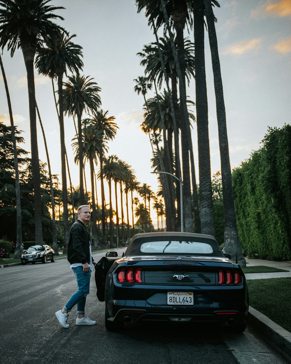 a man walking down the street next to a car