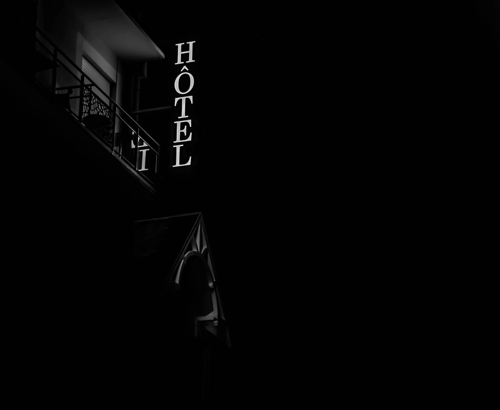 Black-and-white hotel sign glowing at night