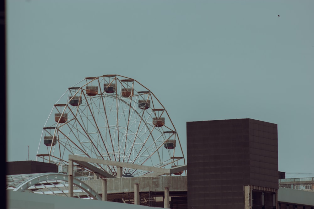 a large ferris wheel sitting next to a tall building