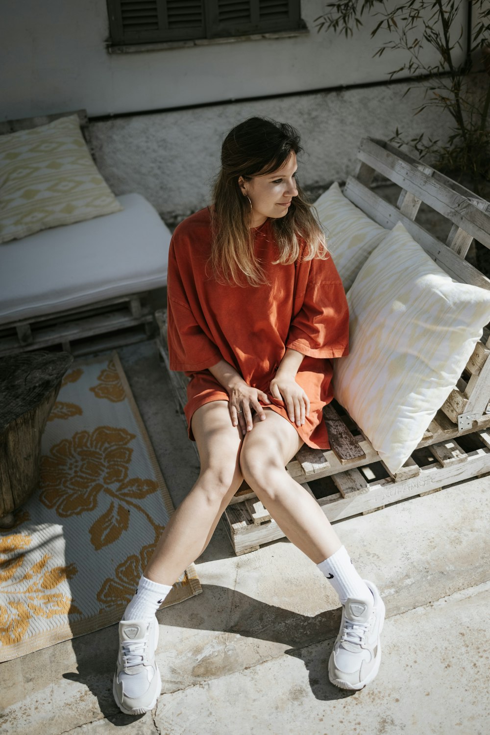 a woman sitting on top of a wooden bench