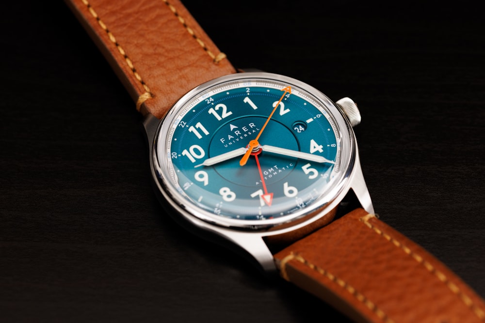 a close up of a watch on a black surface