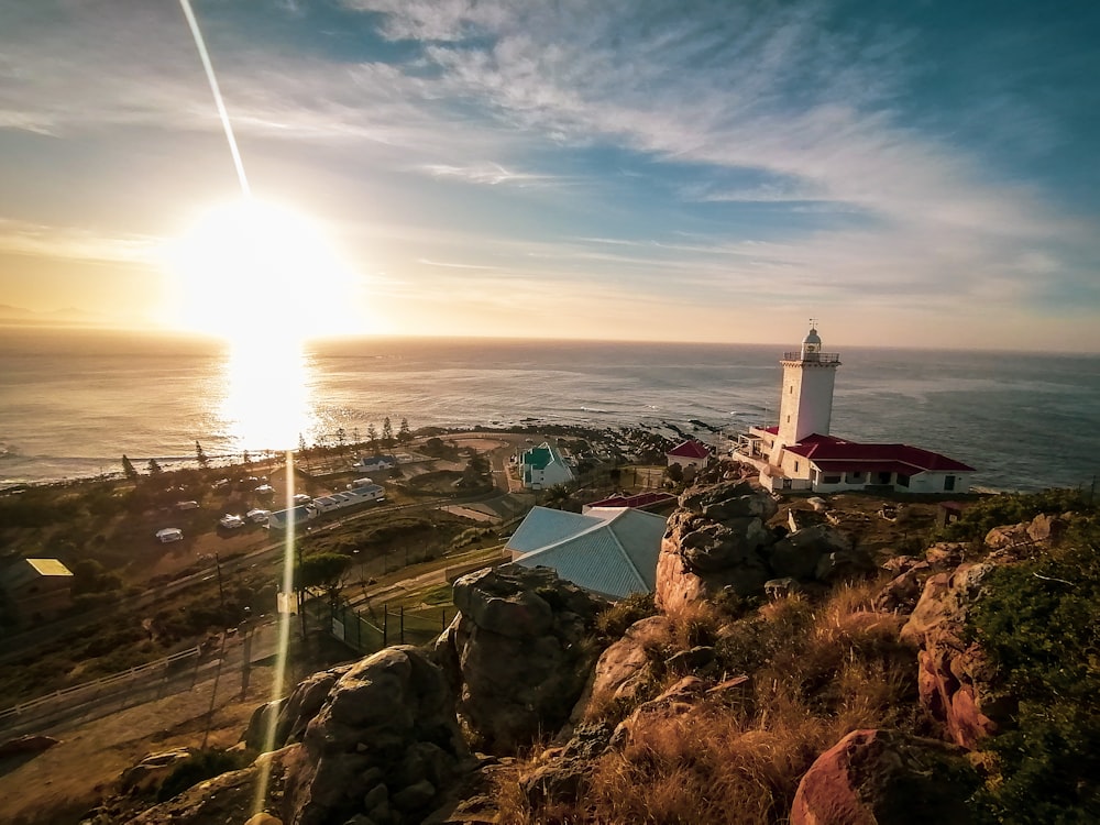 a lighthouse on top of a hill near the ocean