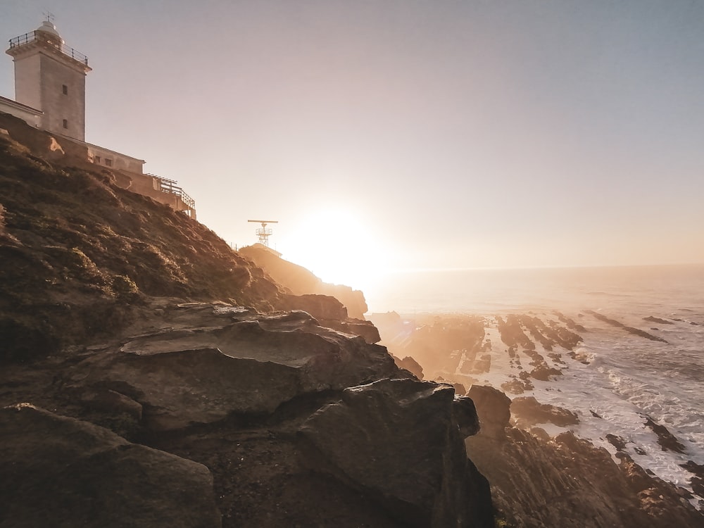 a lighthouse on a cliff overlooking the ocean