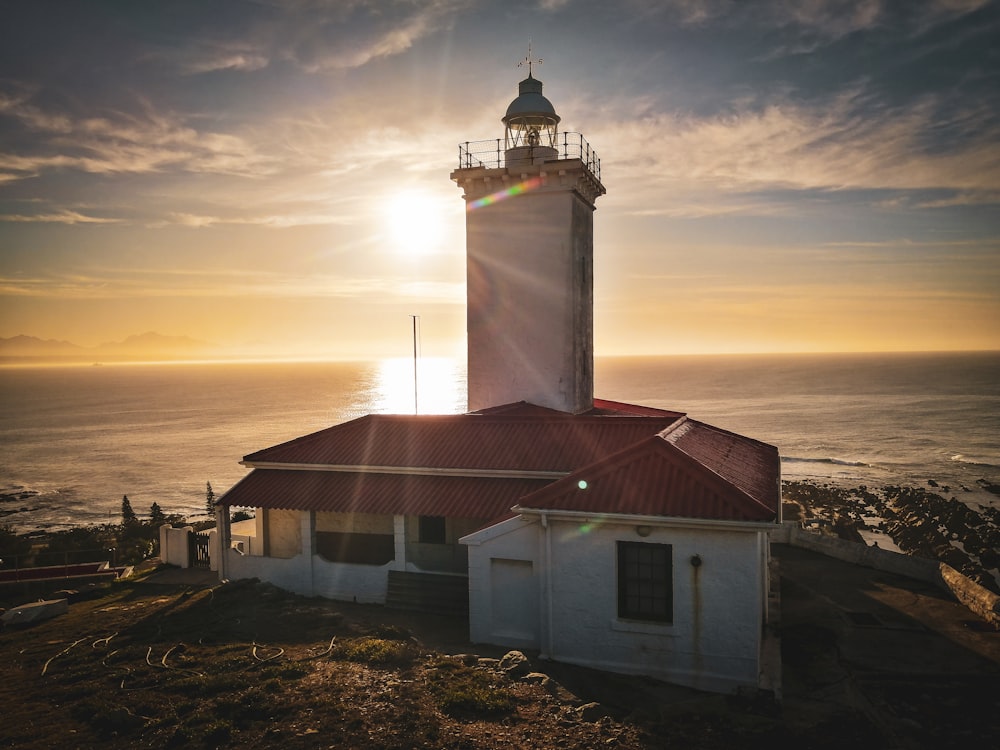 a light house sitting on top of a hill next to the ocean