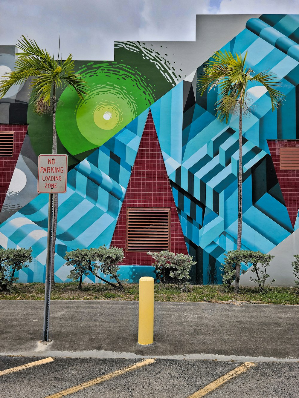 a parking lot with a mural on the side of a building