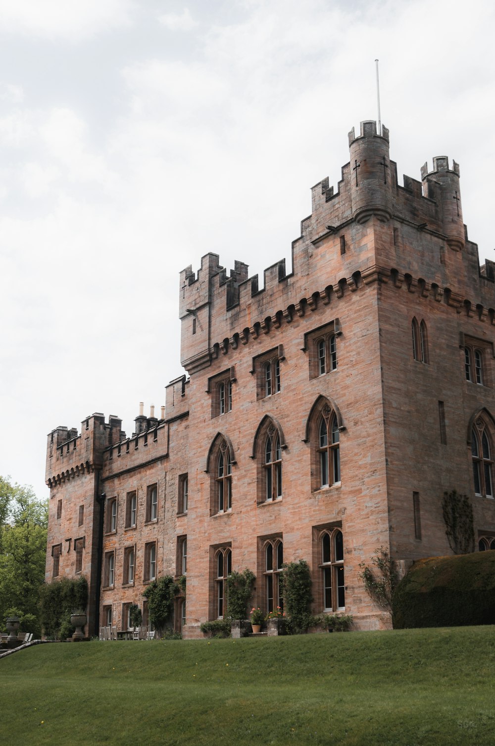 a large brick building sitting on top of a lush green field