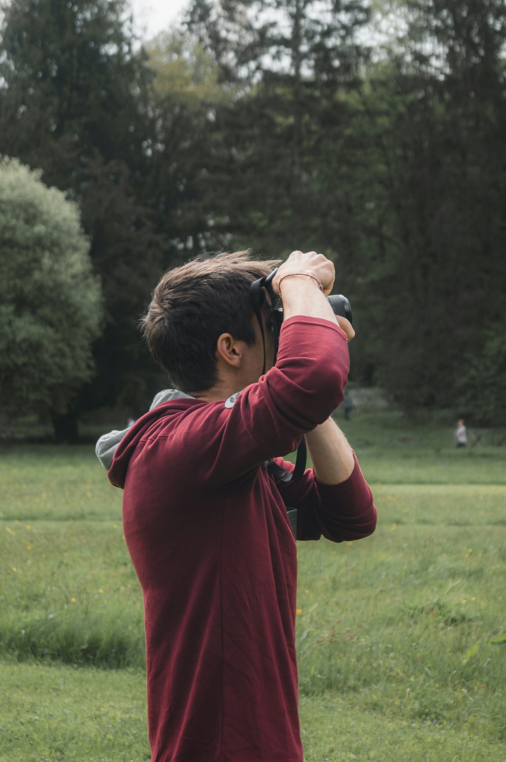 a man taking a picture of a field with a camera