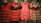 Traditional flamenco dresses hanging on display, featuring vibrant colors and ruffled layers. The dresses showcase polka dot patterns and are predominantly red, pink, and black with varying designs.