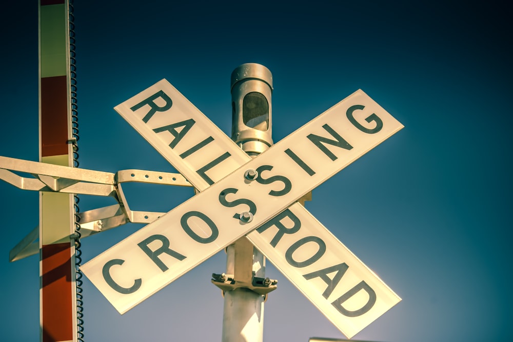 a railroad crossing sign with a railroad crossing sign in the background