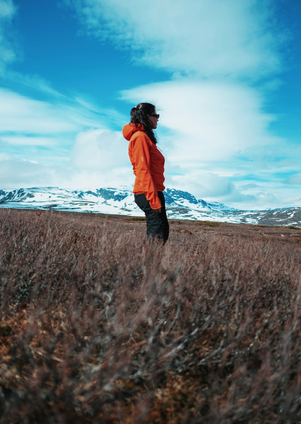 a woman standing in a field of tall grass