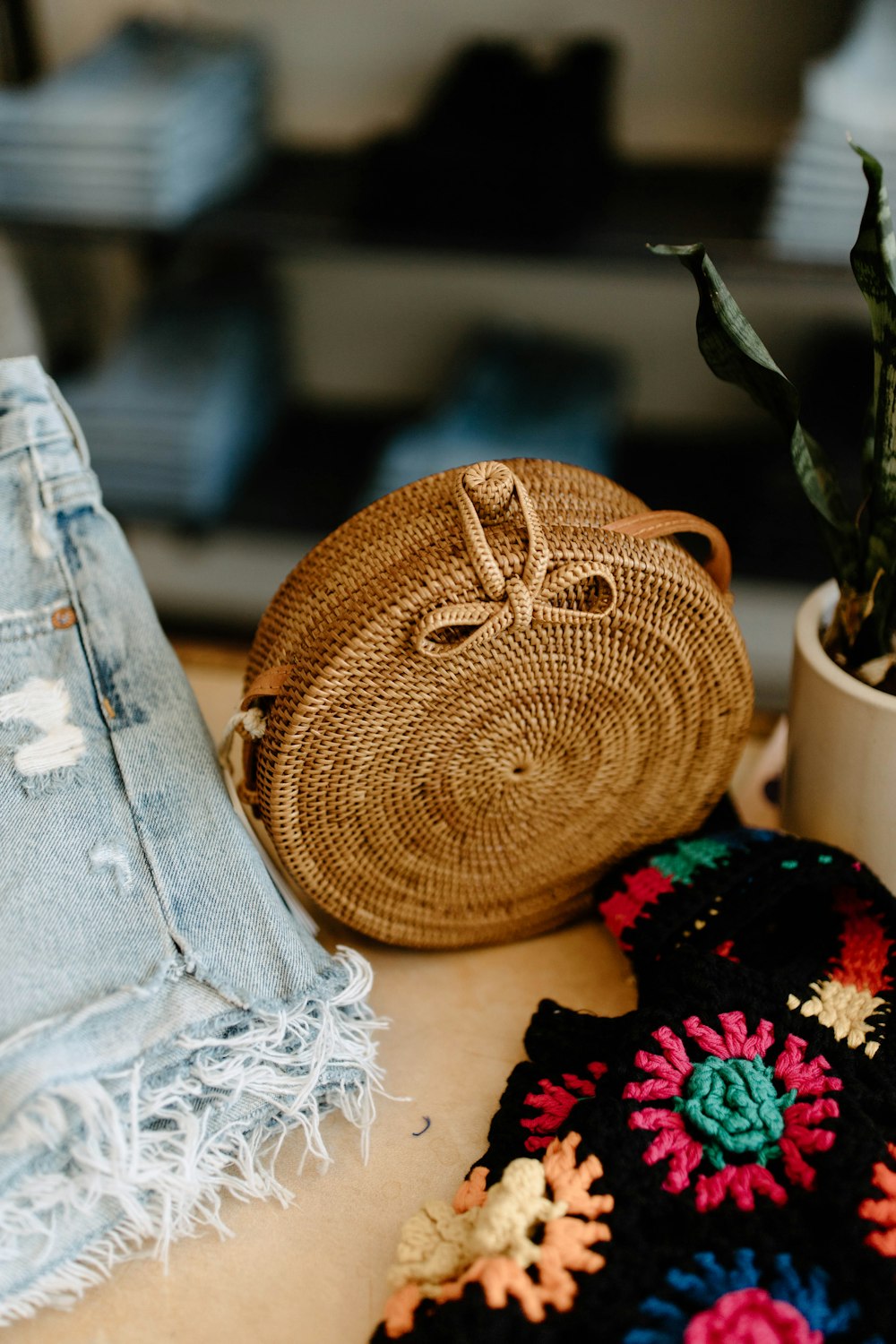 a crocheted purse sitting on top of a table next to a potted