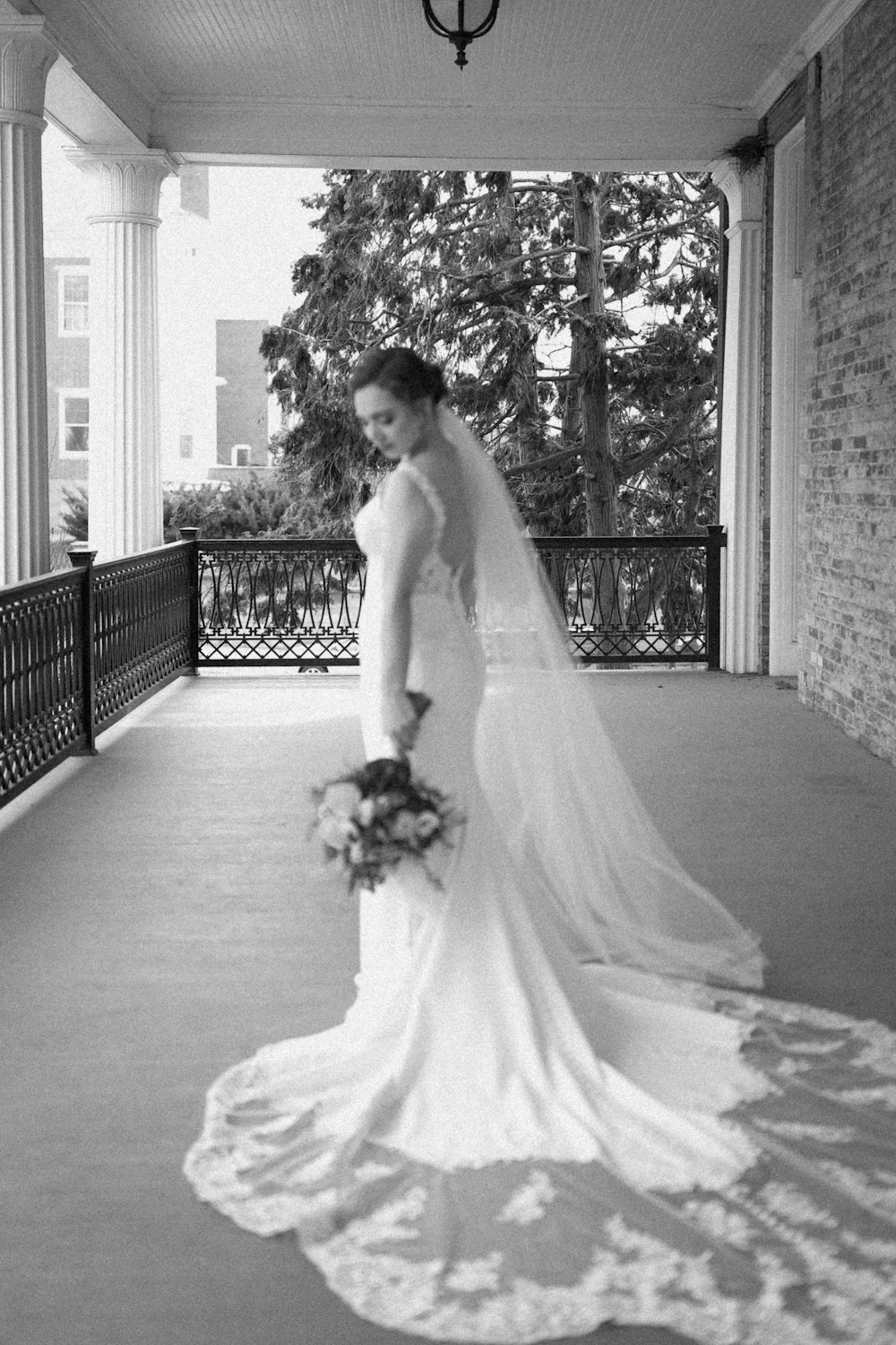a woman in a wedding dress standing on a porch