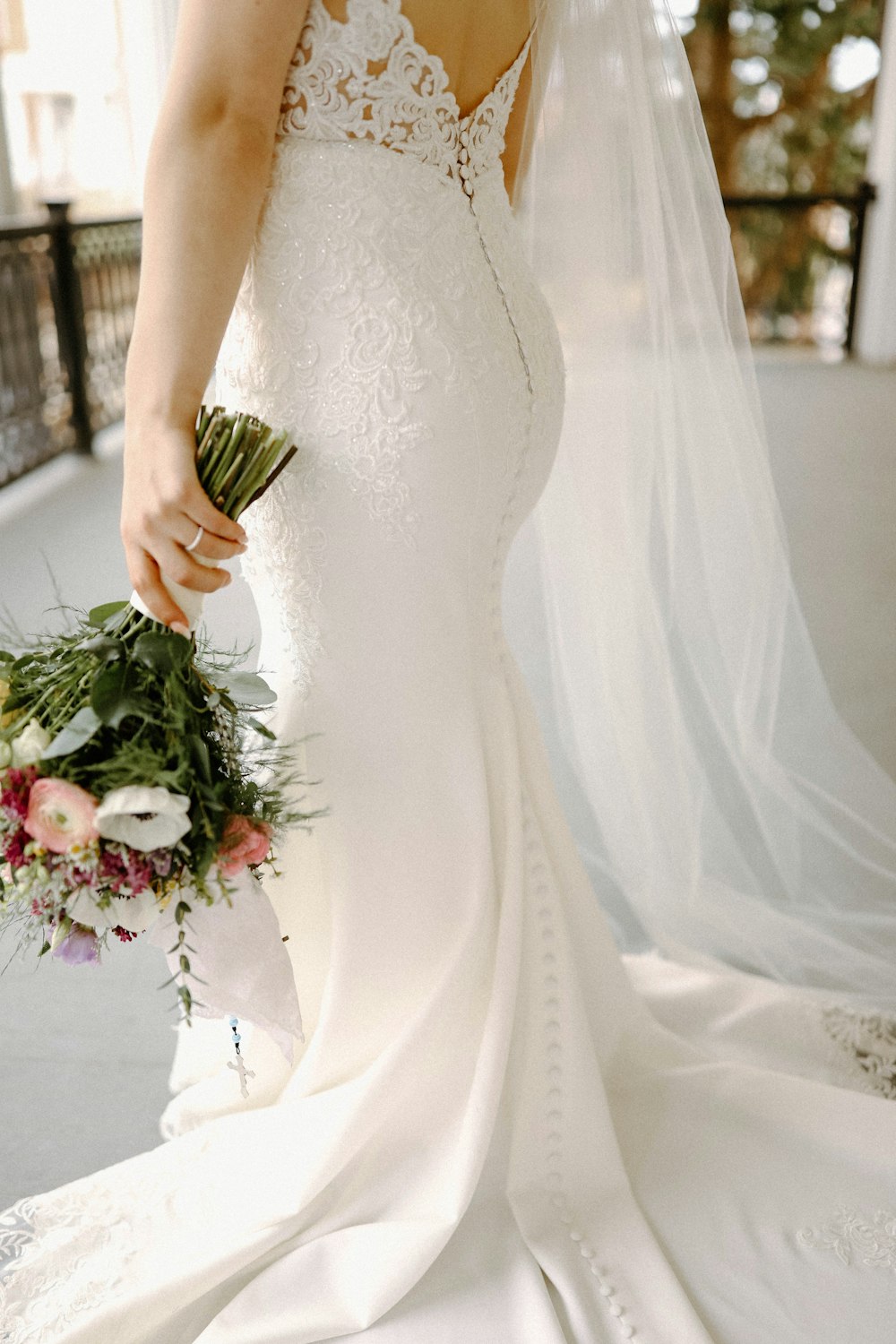 Eine Frau im Brautkleid hält einen Blumenstrauß