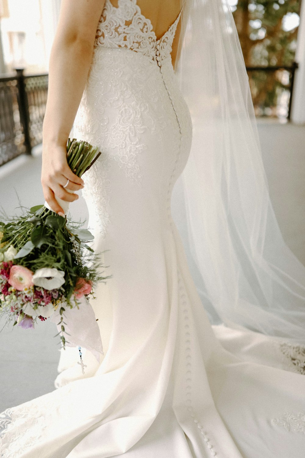 a woman in a wedding dress holding a bouquet of flowers