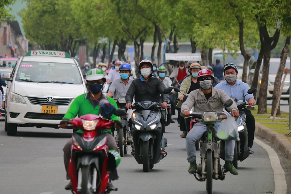 a group of people riding motorcycles down a street