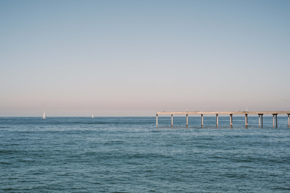 a long pier stretches out into the ocean