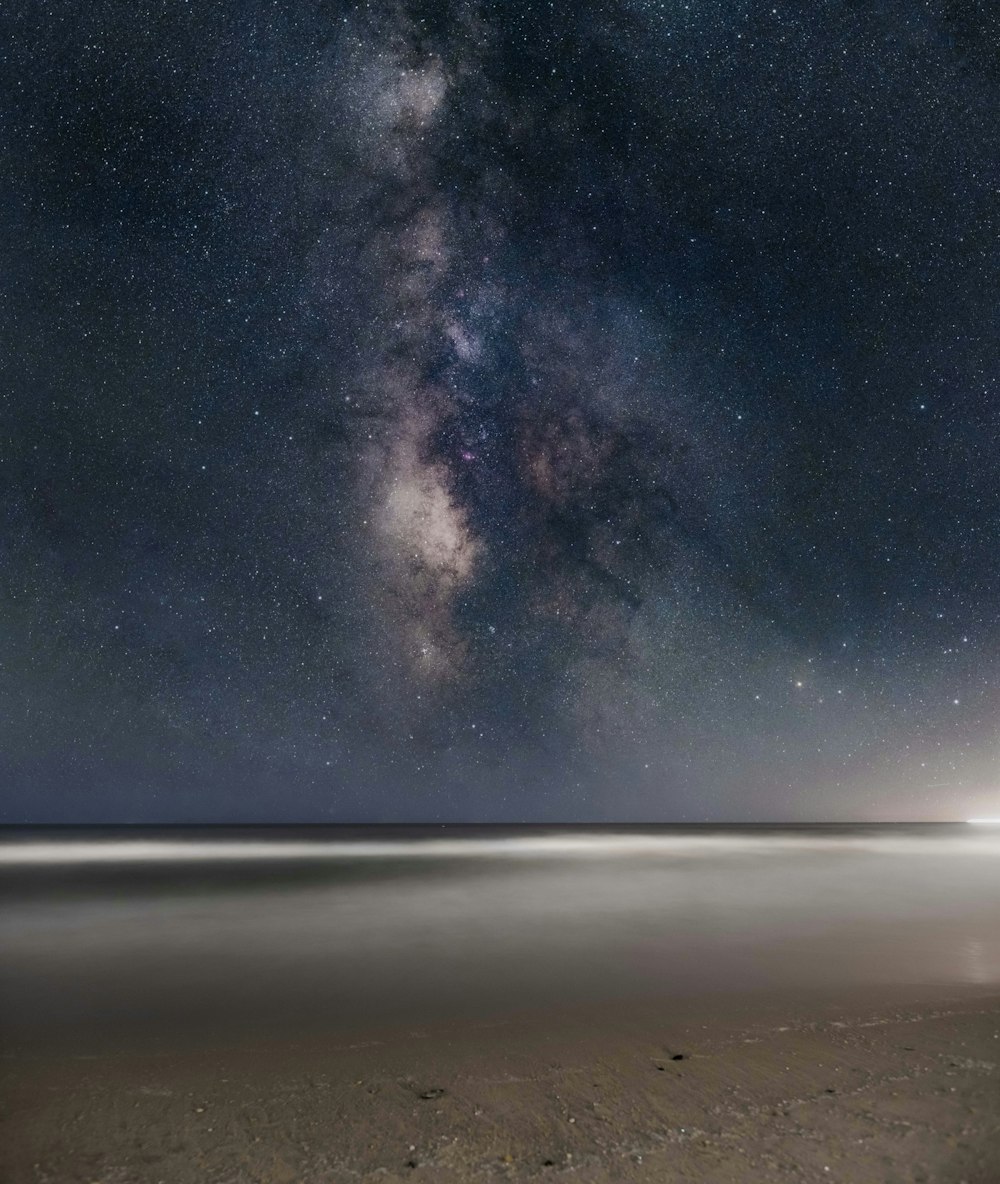 a long exposure shot of the night sky over the ocean