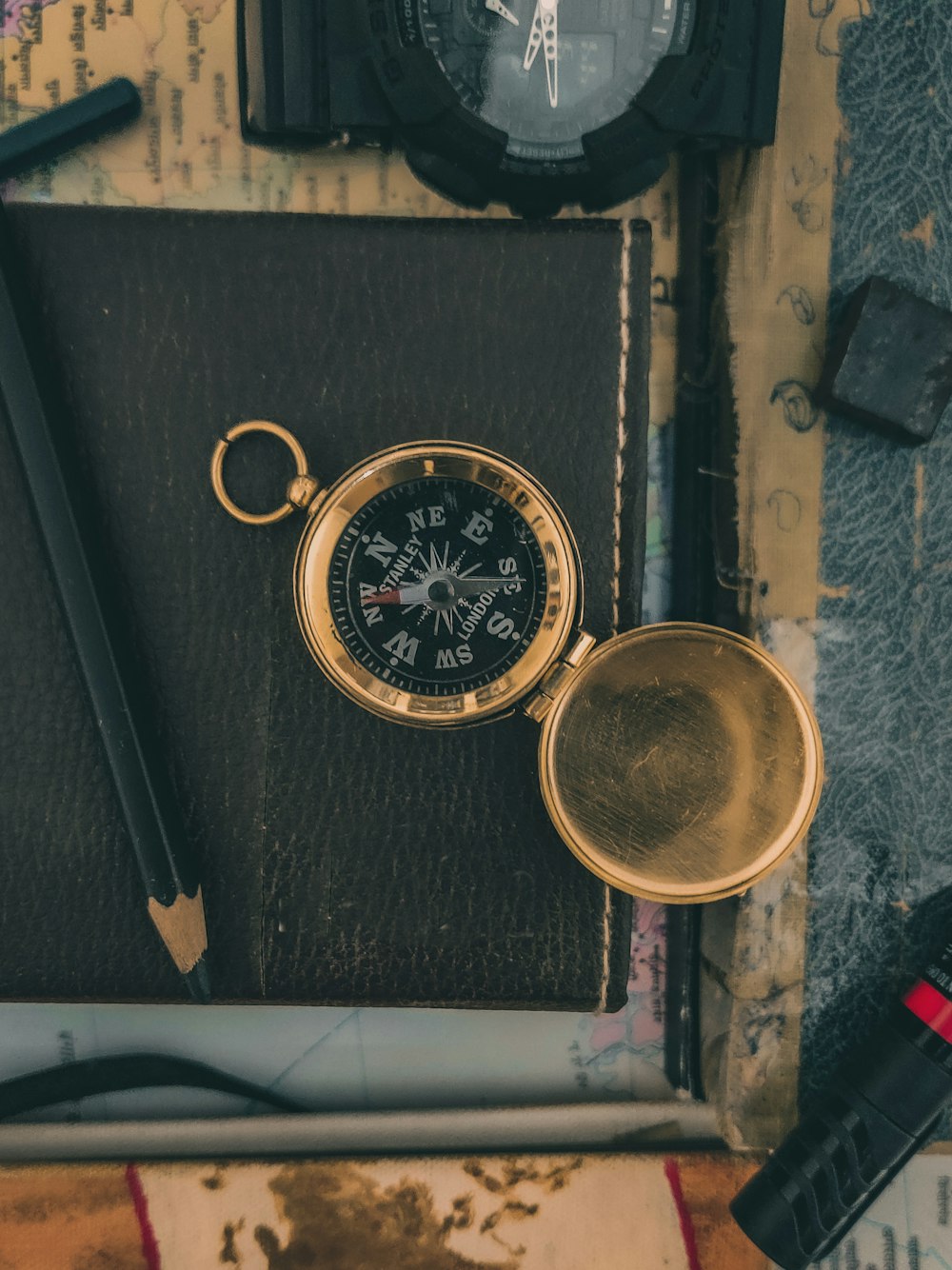 a pocket watch and a compass on a table