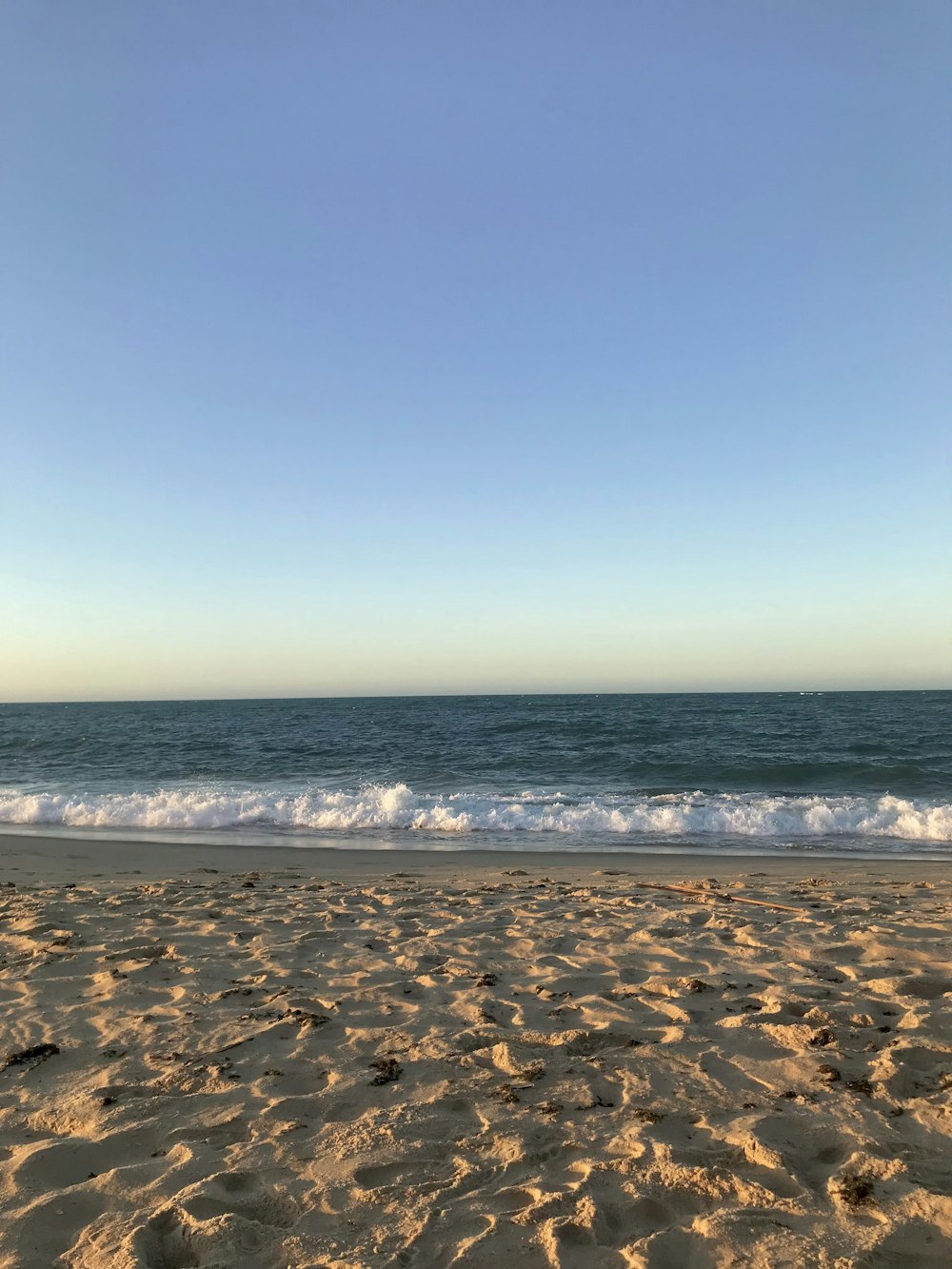 a view of a beach with waves coming in from the ocean