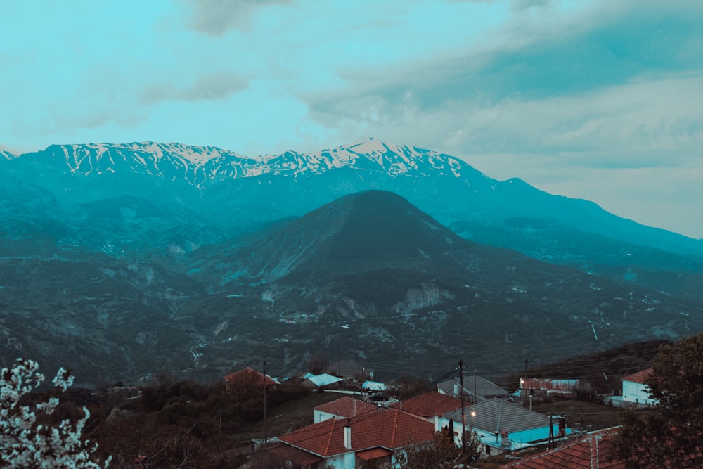 a view of a mountain range with houses in the foreground