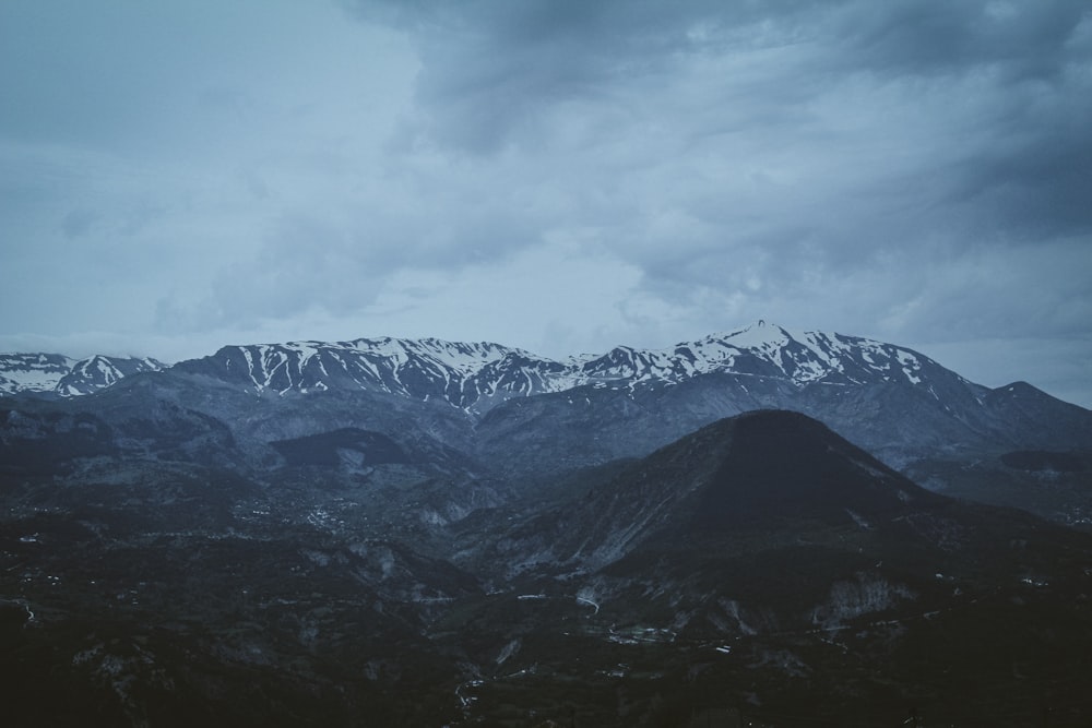 a mountain range with snow capped mountains in the distance