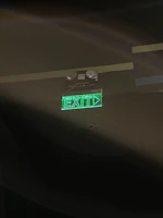 Close-up of a Tiverton Power emergency light glowing softly in a dim hallway.