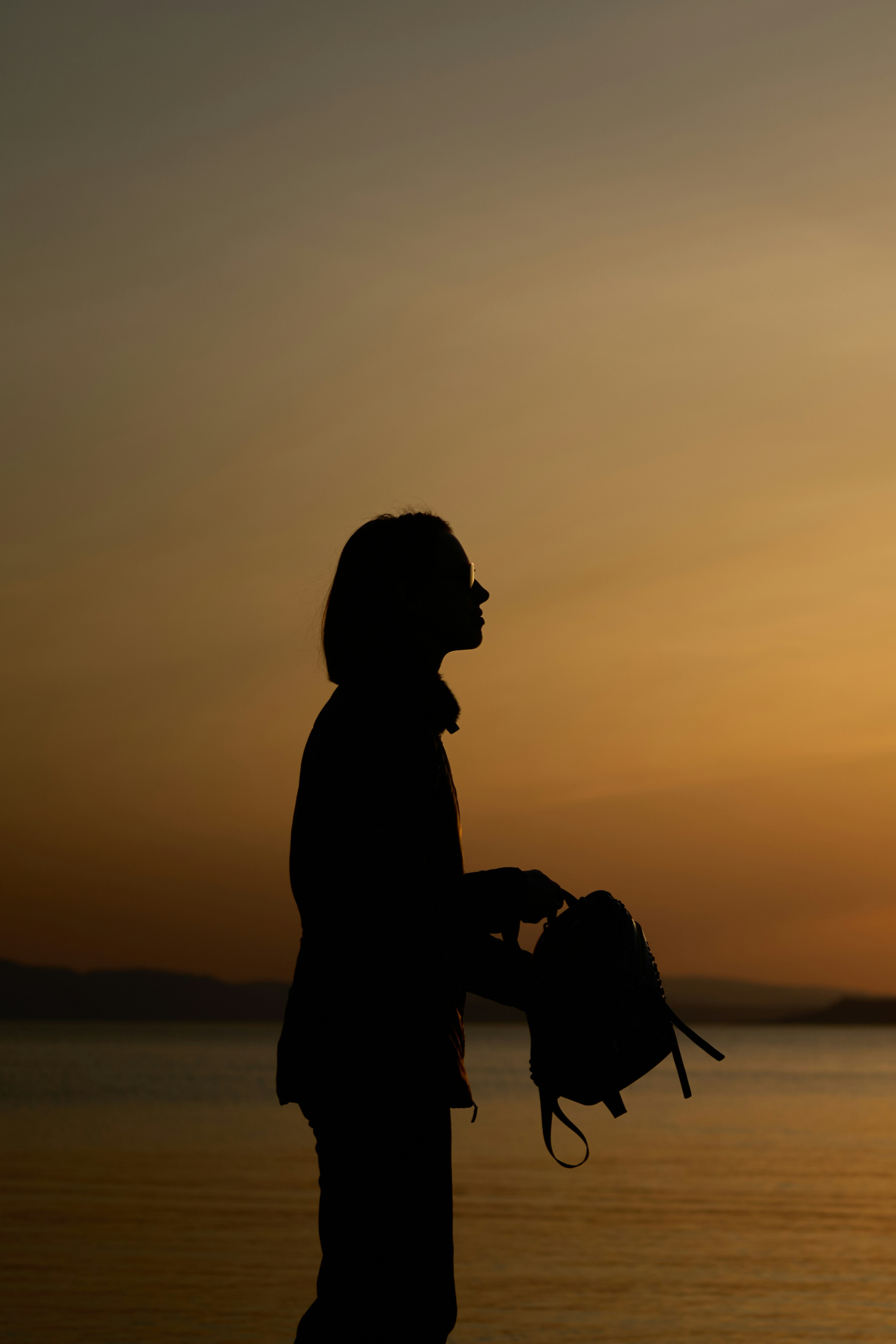 a silhouette of a person holding a small umbrella