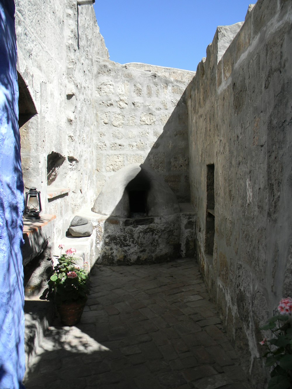 a narrow alley way with a stone building in the background