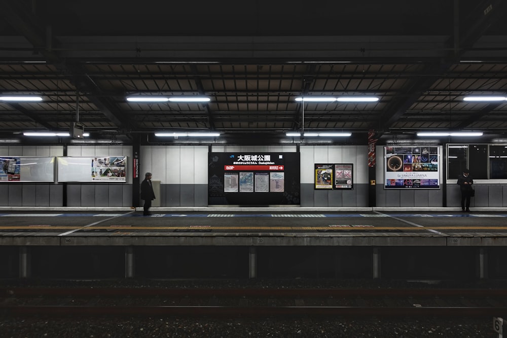 a train station with people waiting for the train