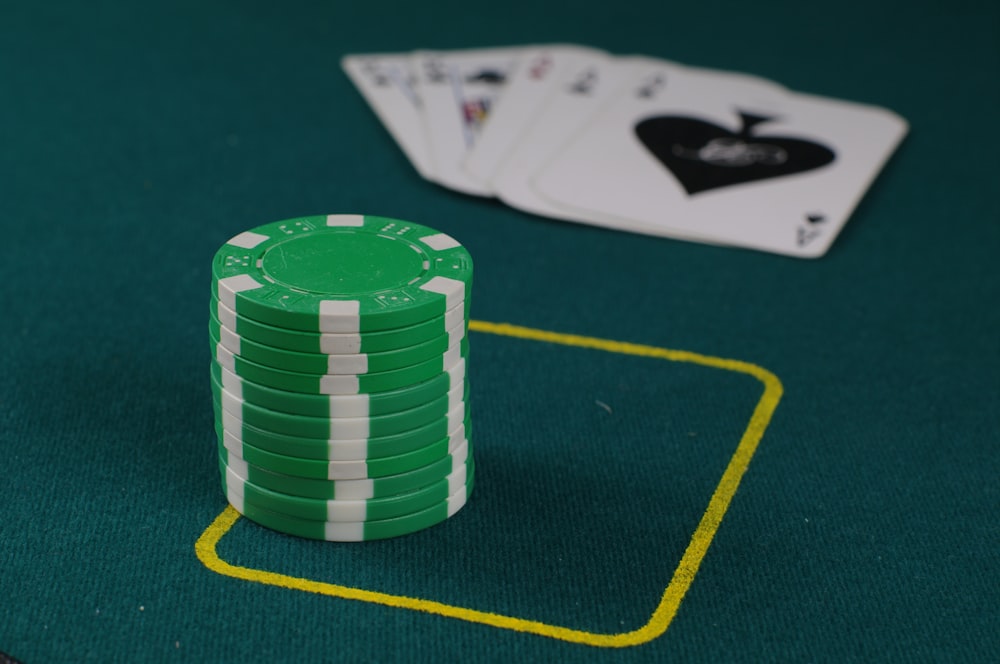 a stack of poker chips sitting on top of a green table