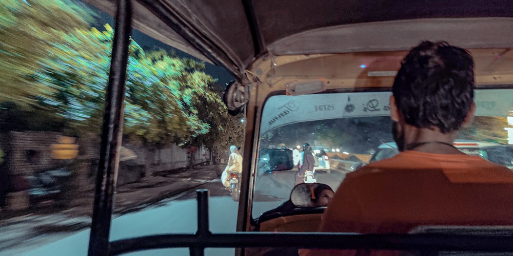 a man driving a bus down a street at night