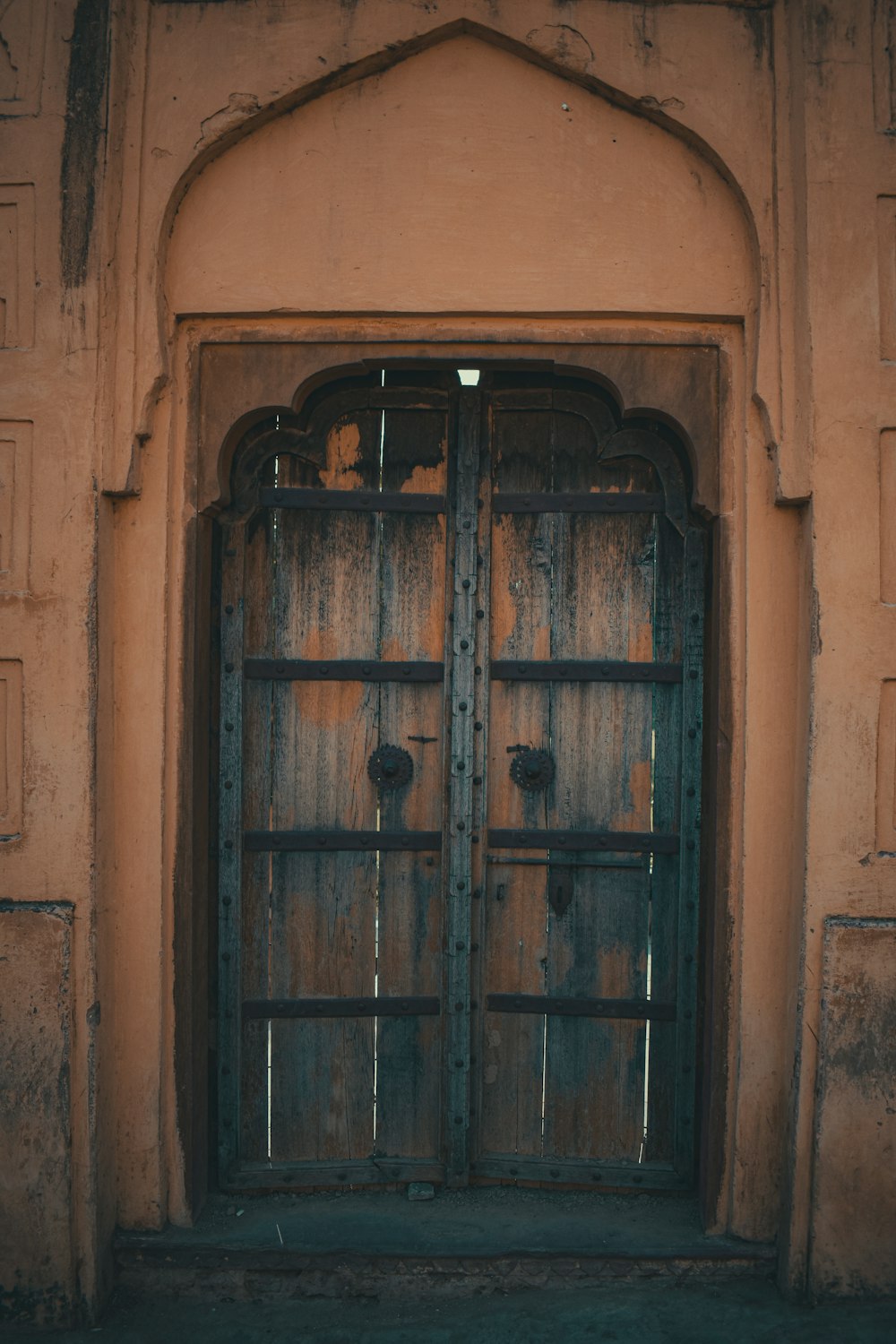 an old wooden door with iron bars on it