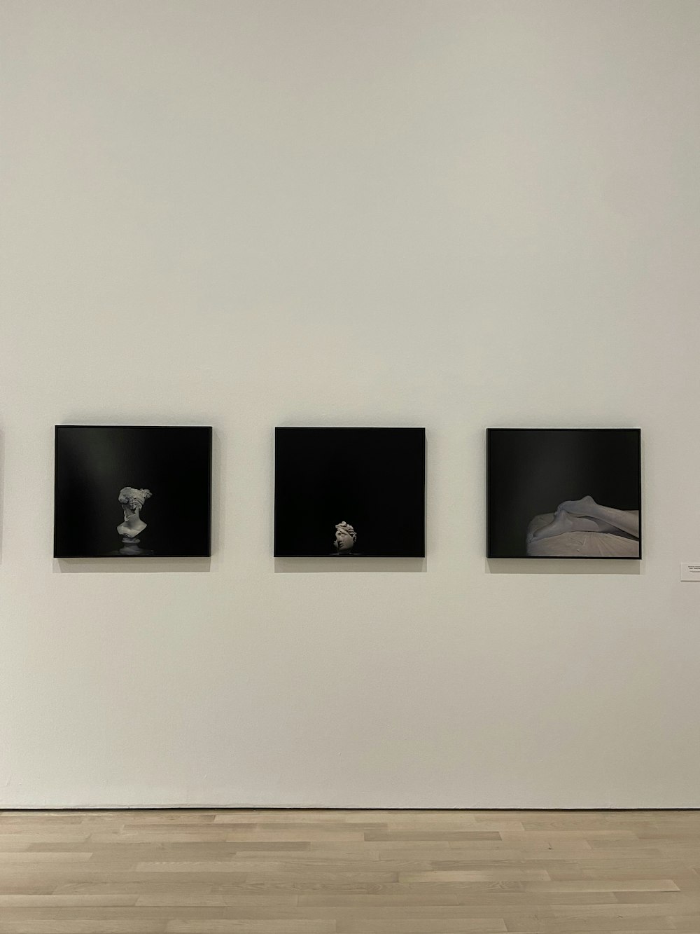 a white wall with three black and white pictures on it