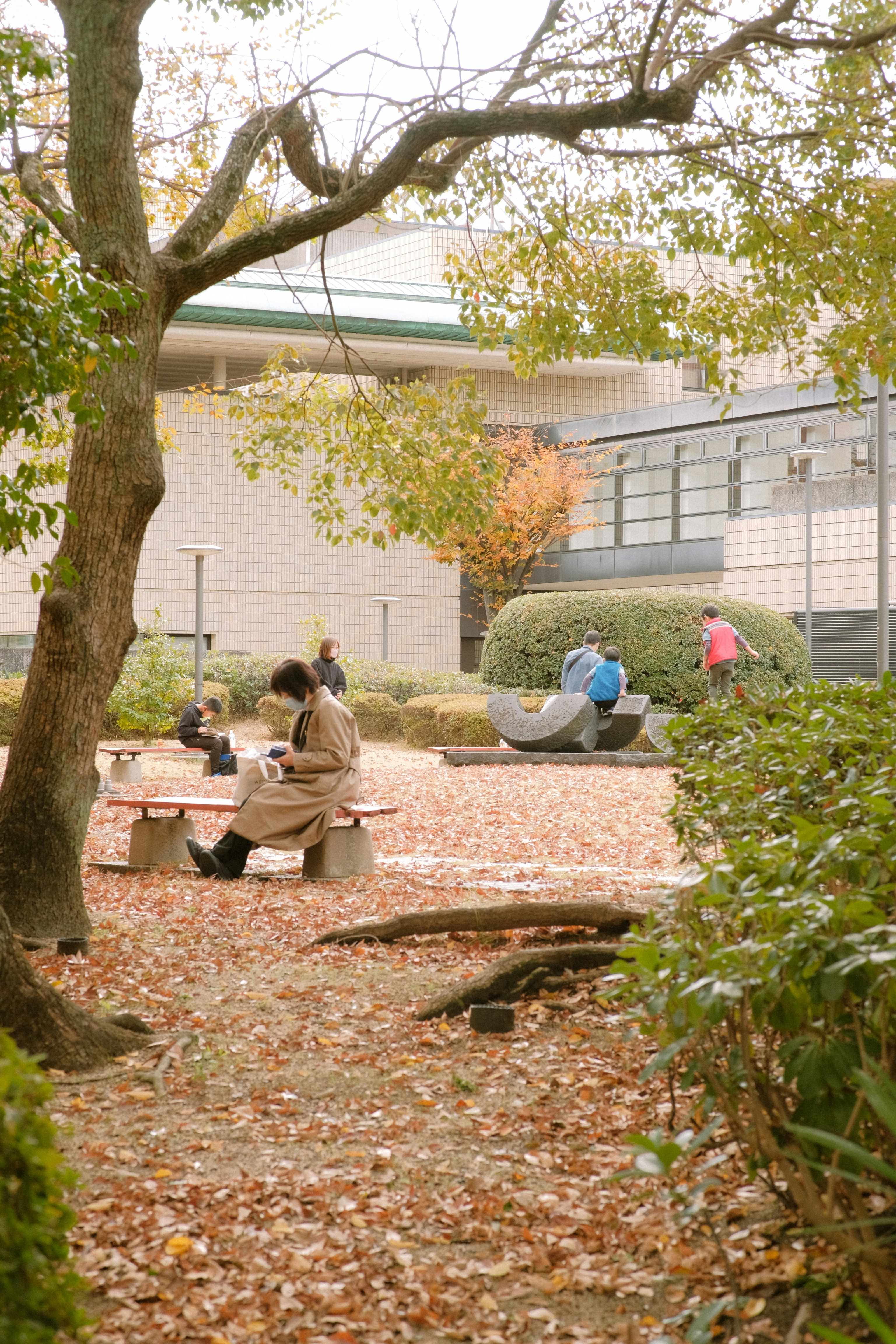 a woman sitting on a bench in a park