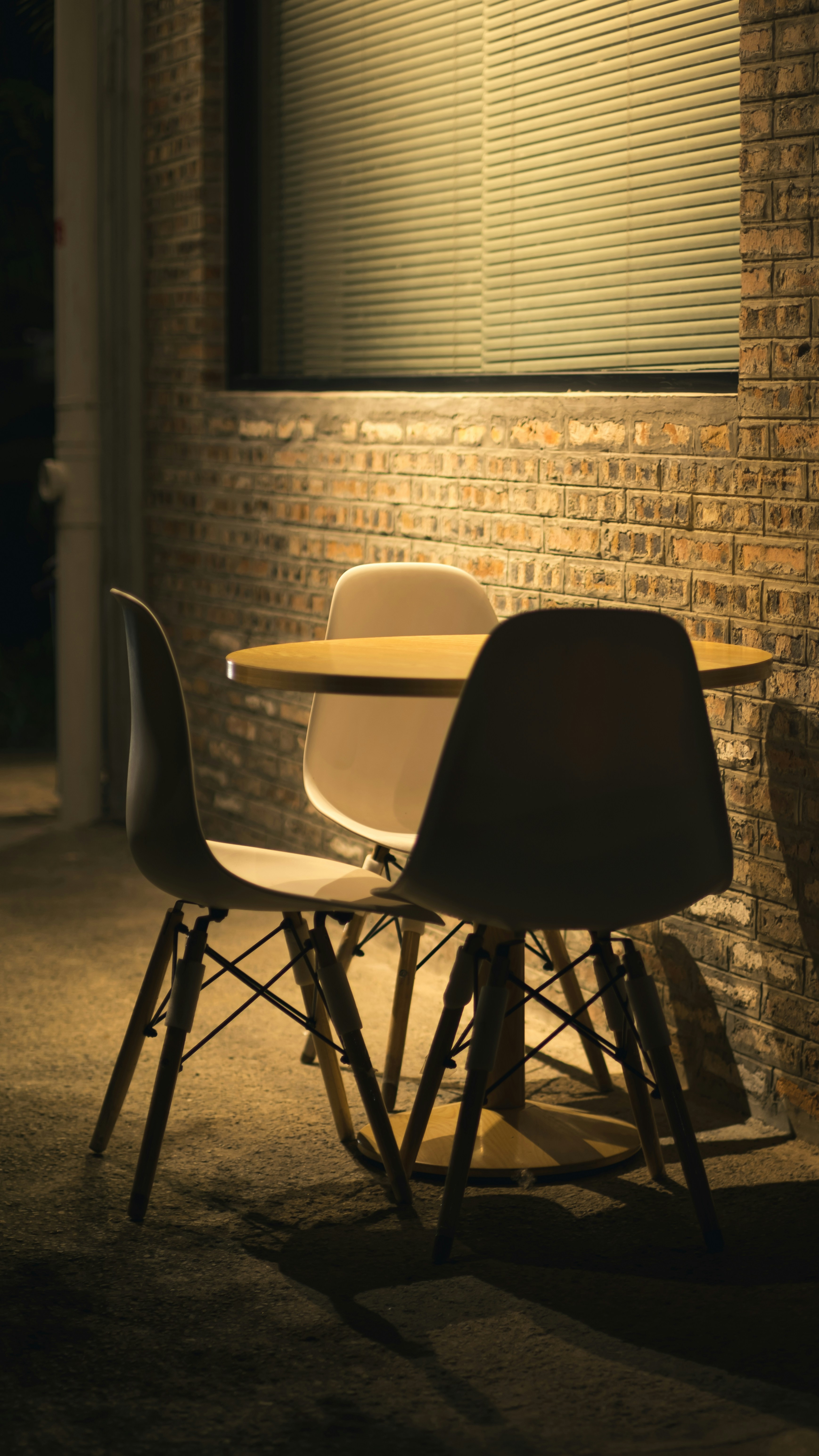 two chairs and a table in front of a brick wall