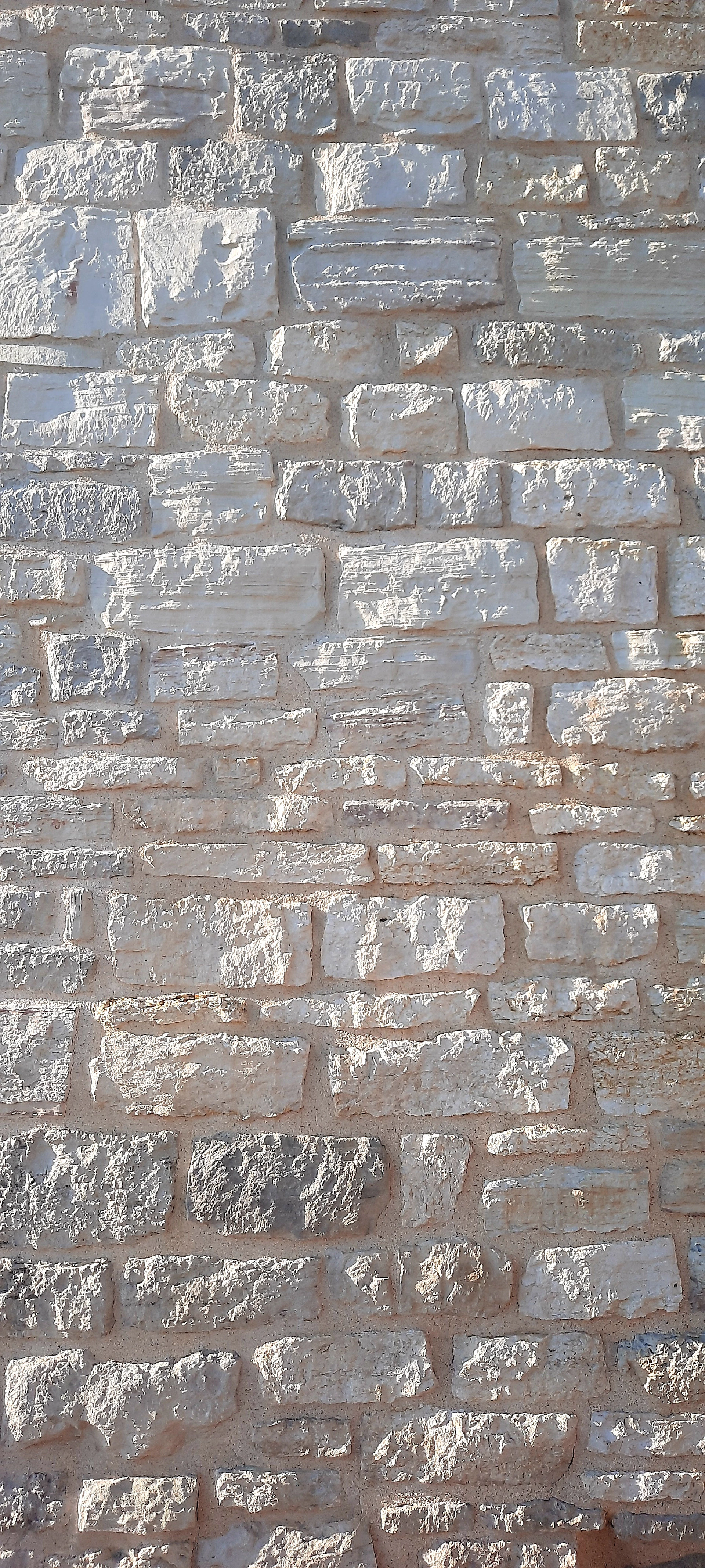 a red fire hydrant sitting on the side of a brick wall