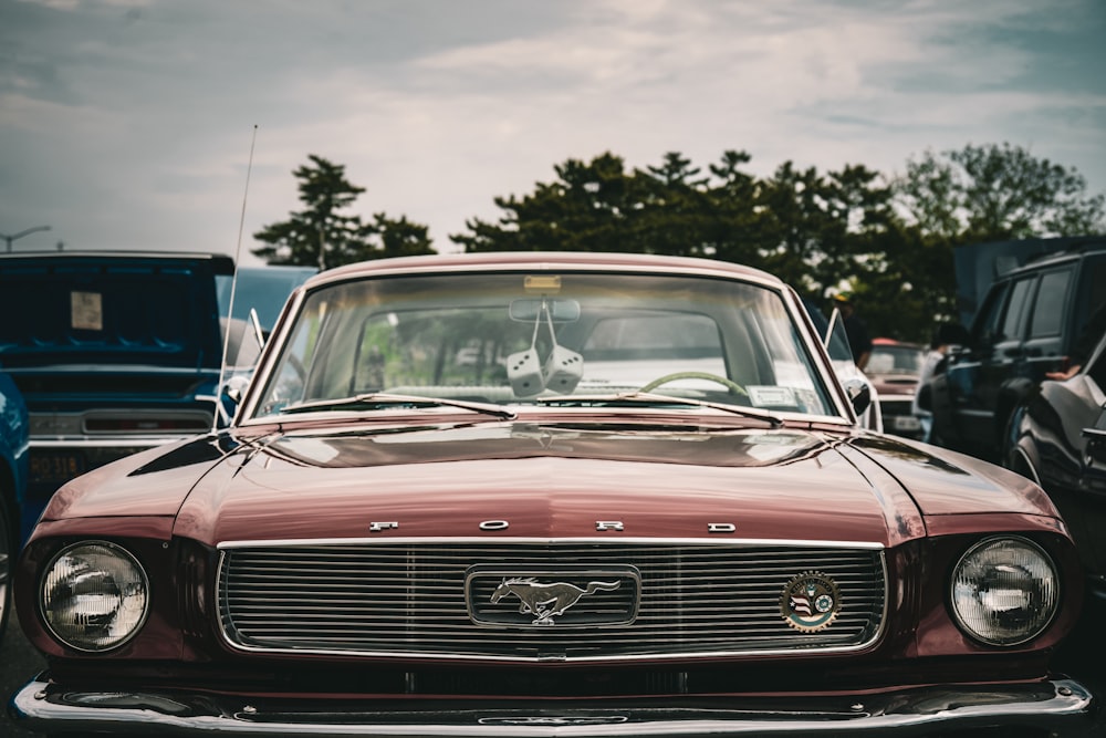 a red car parked in a parking lot next to other cars