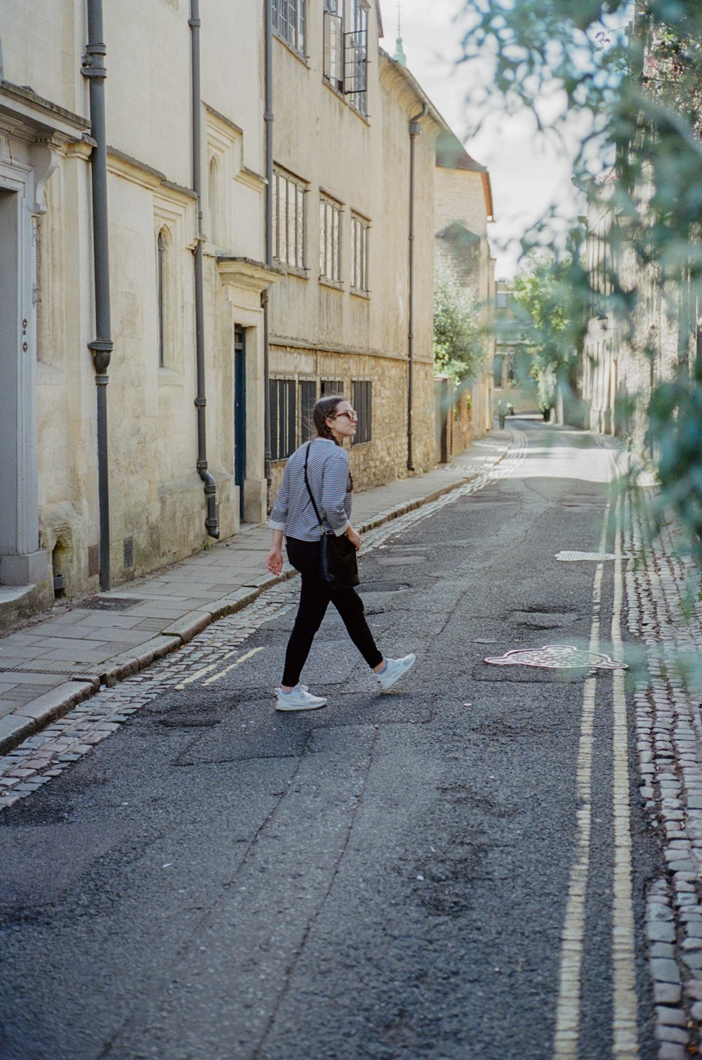 a man walking down a street next to tall buildings