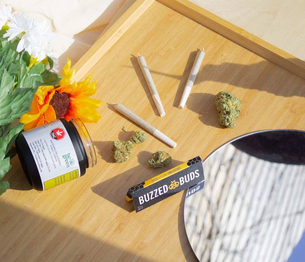 a bunch of marijuana buds sitting on a table next to a vase of flowers