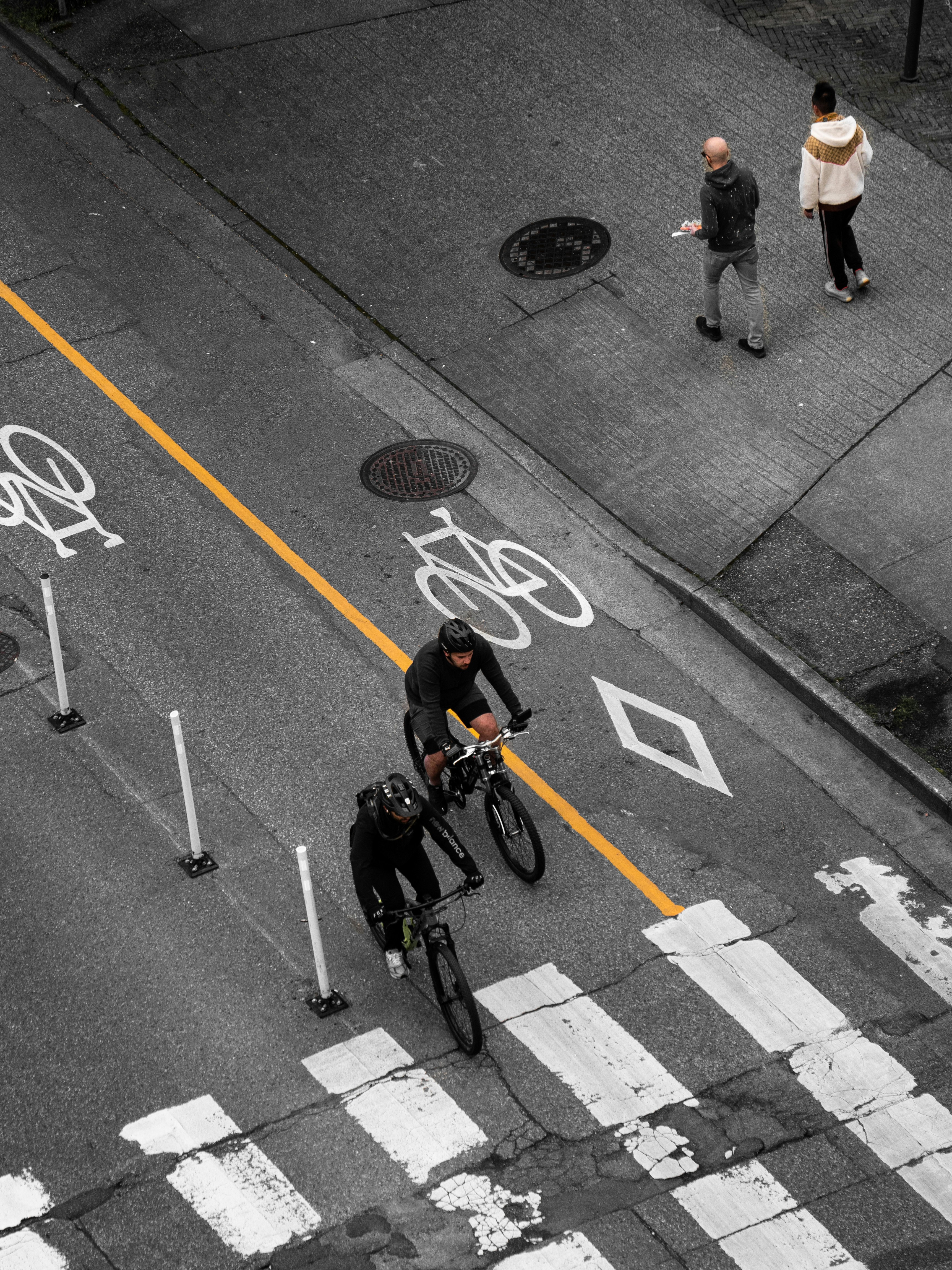 a man riding a bike down a street next to a cross walk