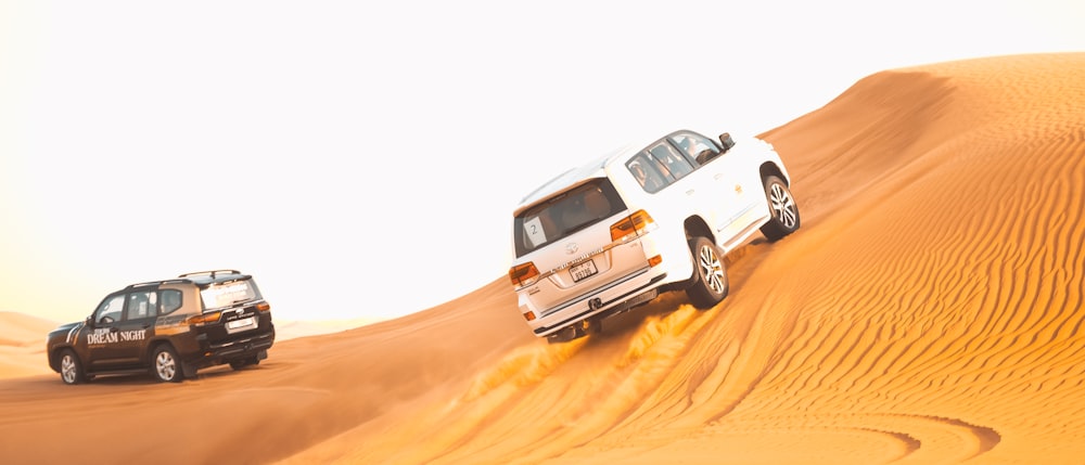 a couple of vehicles driving across a desert