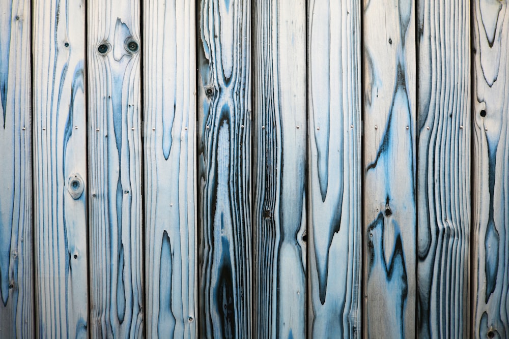 a close up of a wooden fence with blue paint