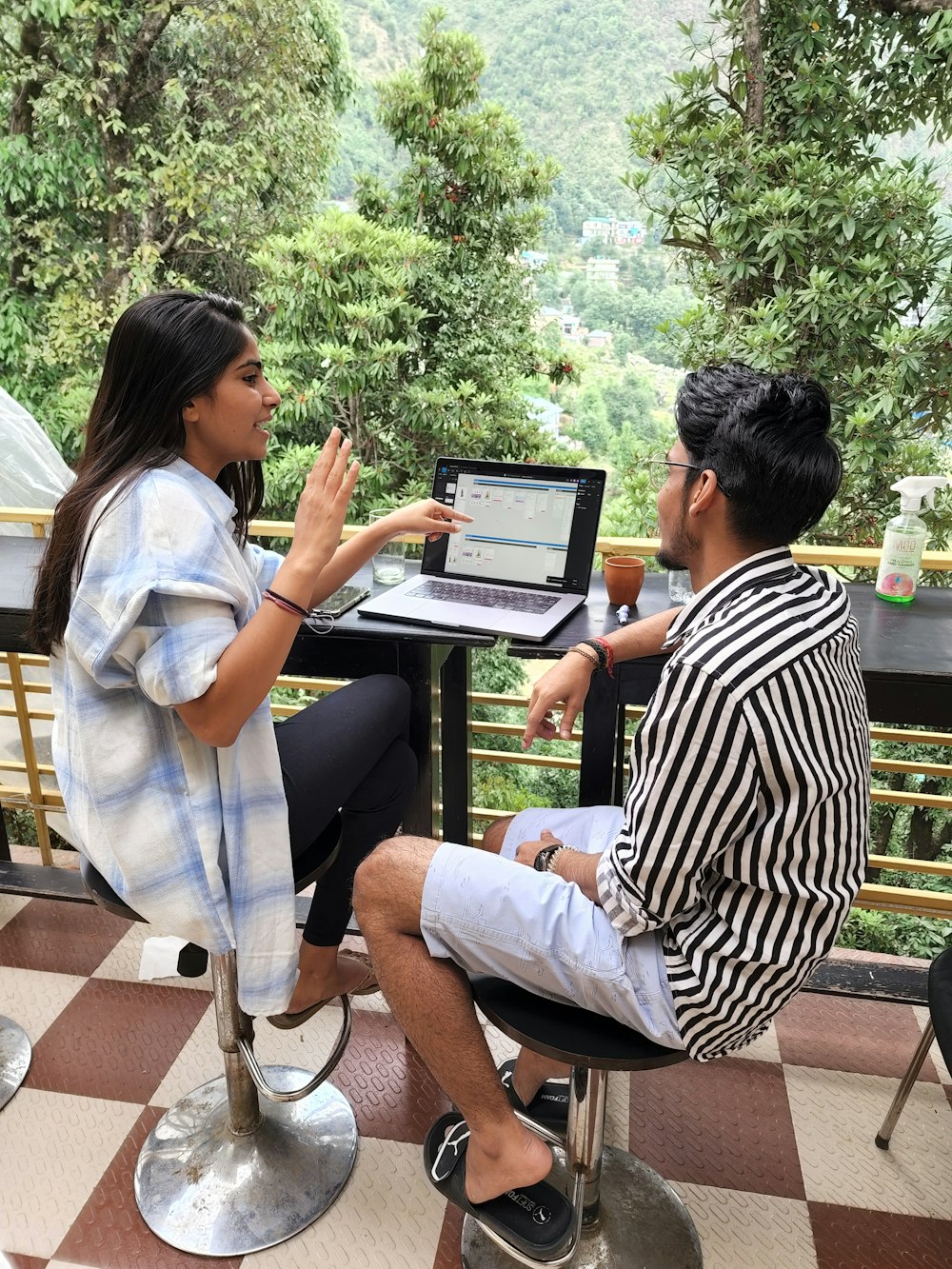 a man and a woman sitting at a table with a laptop