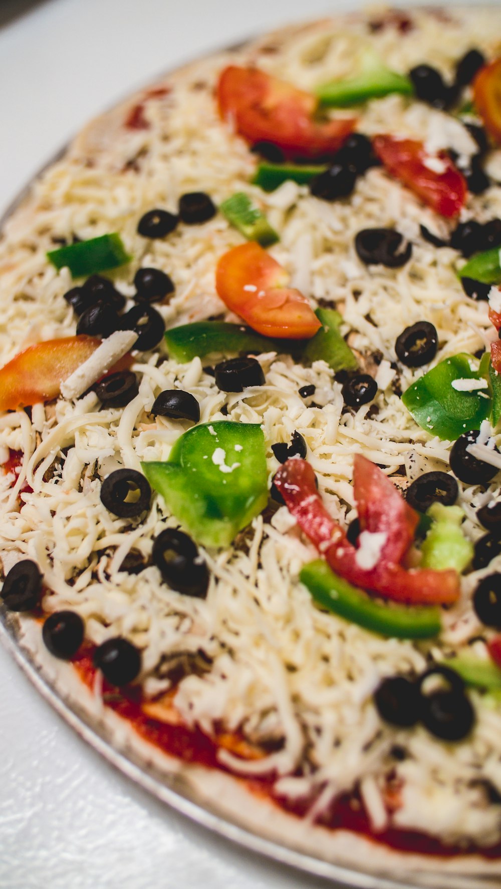 a pizza with cheese, olives, peppers, and cheese