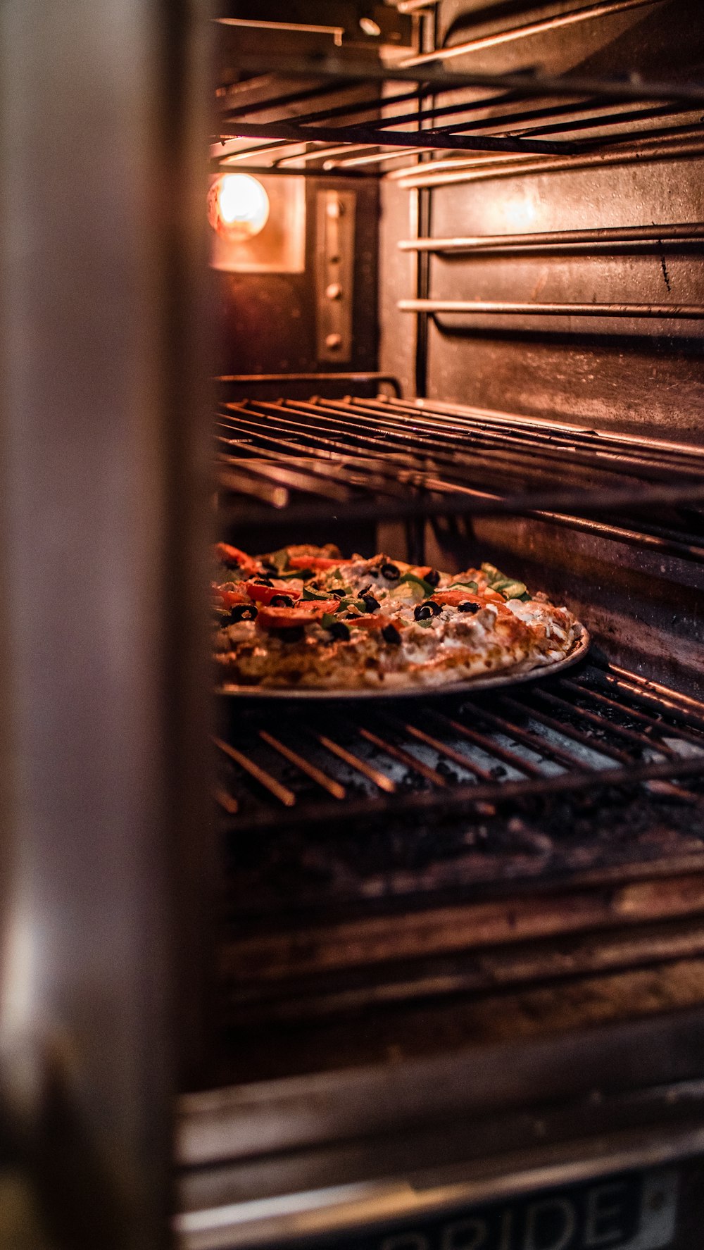 a pizza sitting on top of a pan in an oven