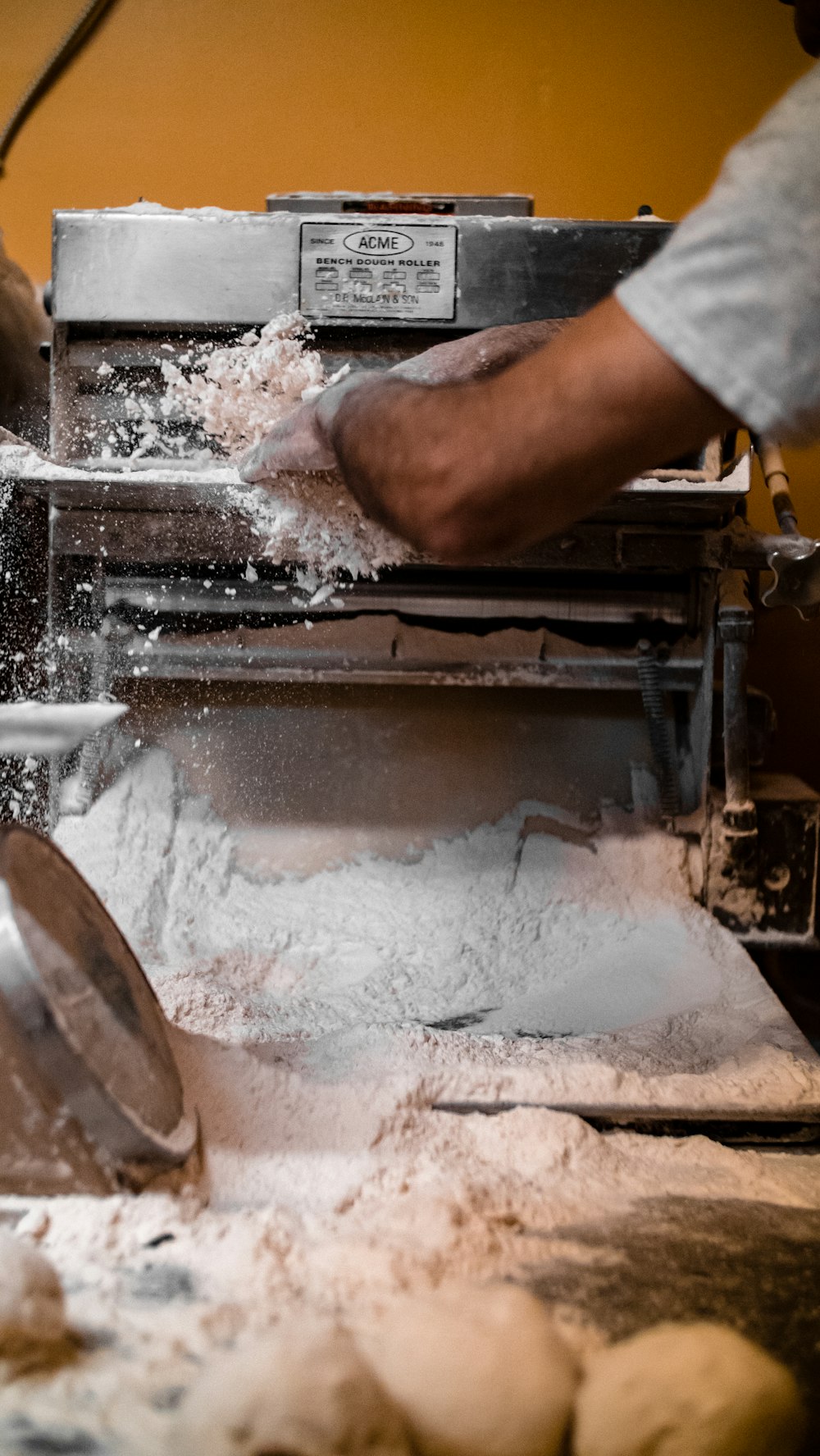 a person making dough on a machine in a kitchen